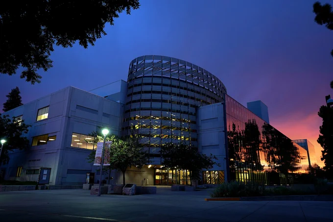 Sunset view of the Library at Fresno State with a vibrant sky and the building's modern architecture highlighted.
