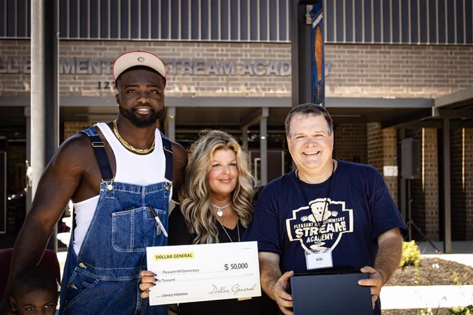 3 people smiling with check in hand.
