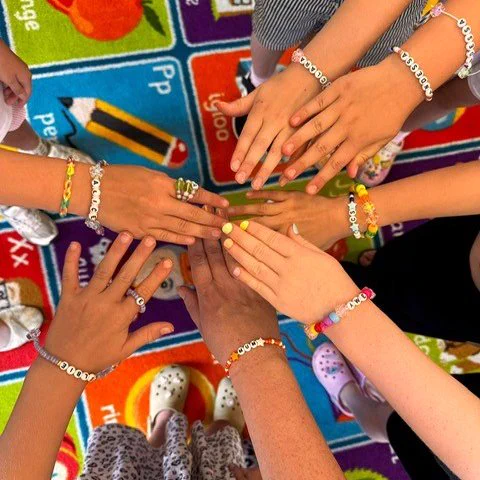 Hands in a circle showing off friendship bracelets