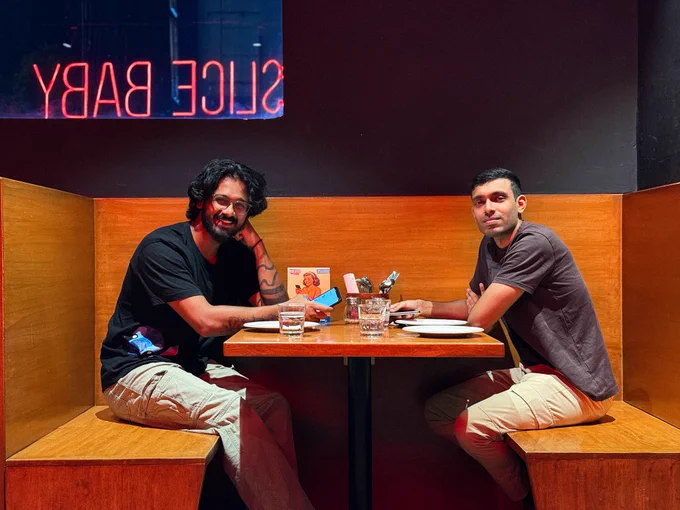 Two handsome men sitting at a diner, Cryptic Comet.