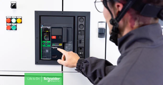 Eine Person in grauer Jacke und Brille bedient den Schneider Electric Leistungsschalter MasterPact MTZ Active.