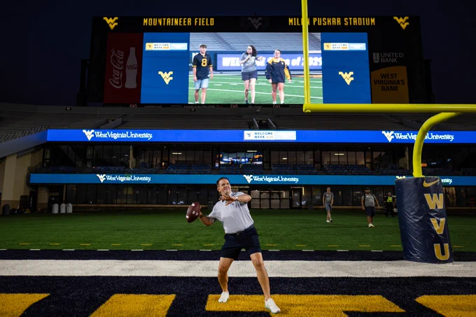 President Michael T. Benson throws a football on Mountaineer Field during Sunday Night Lights.