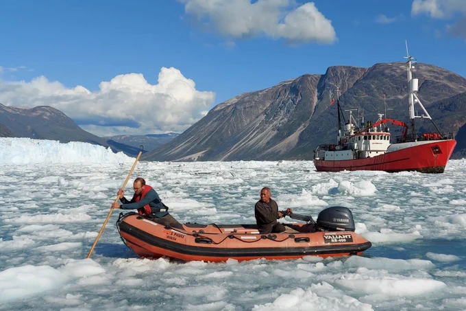 a team of researchers in a boat surrounded by ice