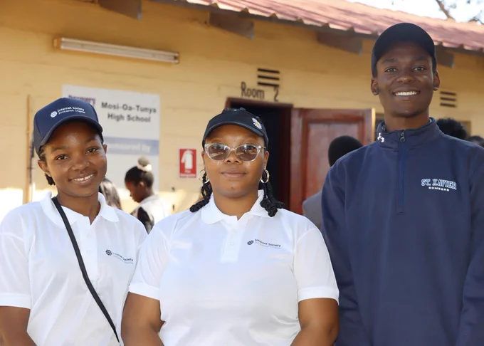 Three people stand together. The two women on the left wear white Internet Society Zimbabwe polos.