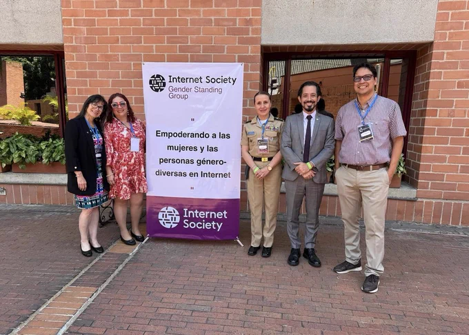 Five people stand outside next to an Internet Society Gender Standing Group sign.