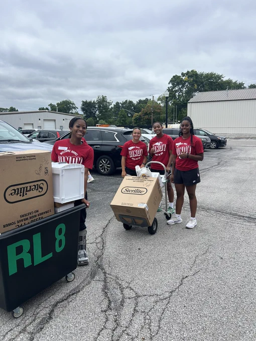 Greyhound players assist during campus move-in day, unloading belongings and supporting freshman