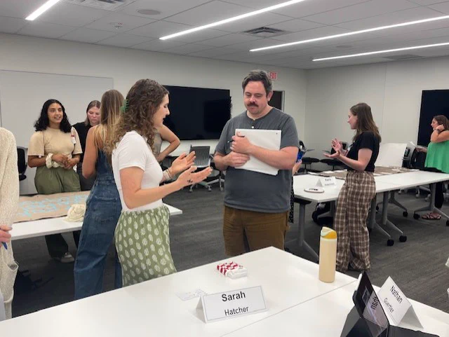 First year OT Student, Sarah Hatcher, and Dr. Adam Snyder talking about Sarah's artifact at her table. 