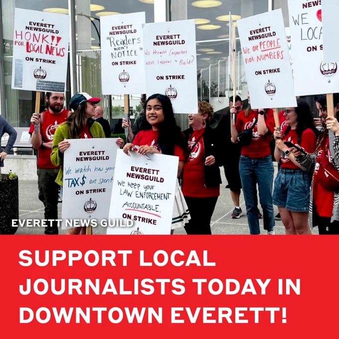 This is a photo from the Everett News Guild of Everett Herald journalists picketing and on strike wearing union shirts and holding signs that say "Honk of Local News!" "We are people not numbers!" and "We watch how your tax dollars are spent!" Text superimposed on the photo says "Support Local Journalists Today in Downtown Everett!"