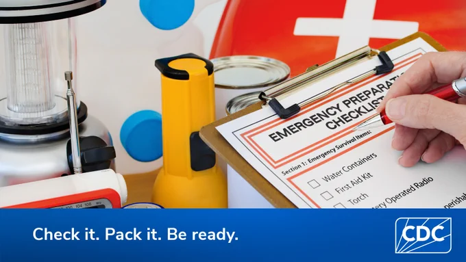 Person with a pen writing on the Emergency Preparedness Checklist with emergency kit supplies on the table.  Text on image reads “Check it. Pack it. Be ready.” 
