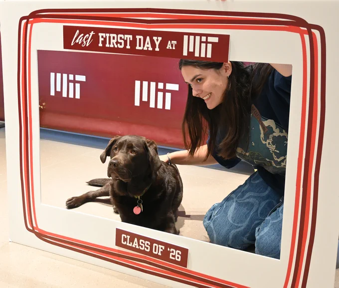 A student and Winni the UAC's dog pose for a photo.