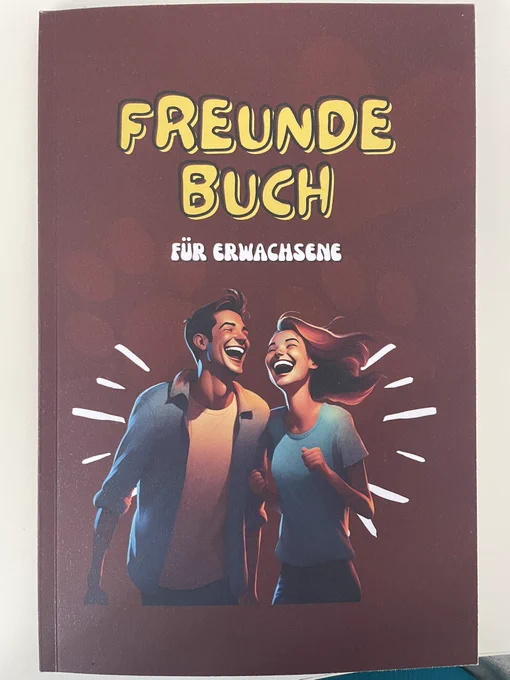 Das Büchlein „Freundebuch für Erwachsene“ mit zwei gezeichneten Figuren - einer Frau und einem Mann, die sich lachend in den Armen liegen.