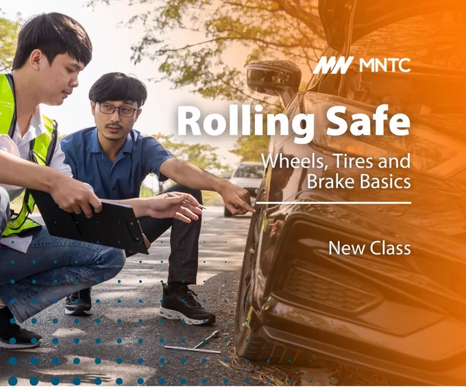 Two individuals inspect a car's wheel during a MNTC Rolling Safe class, focusing on wheels, tires, and brake basics.