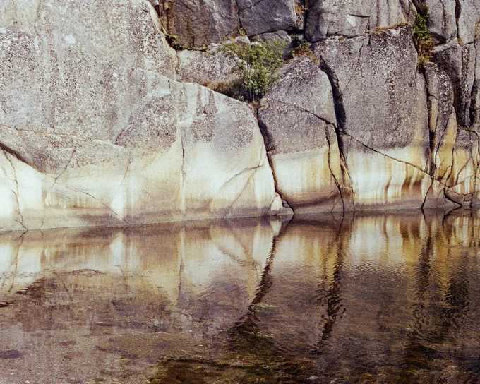 Clifs along the sea shore, reflecting in the water on a sunny day.