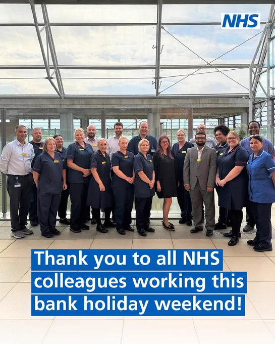 A group of medical staff standing and smiling at the camera in a hospital. Text below the group says ‘Thank you to all NHS colleagues working this bank holiday weekend!’. 