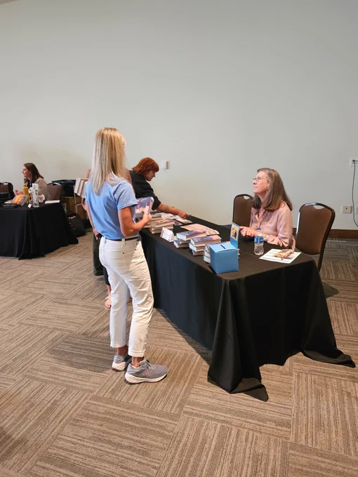 Author Megan E. Freeman signs books for DCSD Librarians