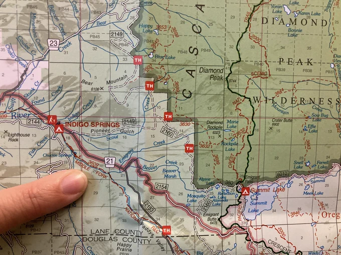 A finger points to a map of the location of a wildfire