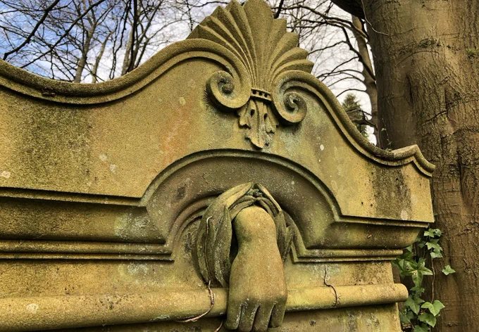 Close up of a grave in Cathcart Cemetery with a sculpted hand in the stonework.