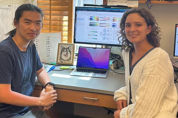 Teng-Jui (Owen) Lin and Kylee Hillman sit at a desk with a computer and monitor behind them.