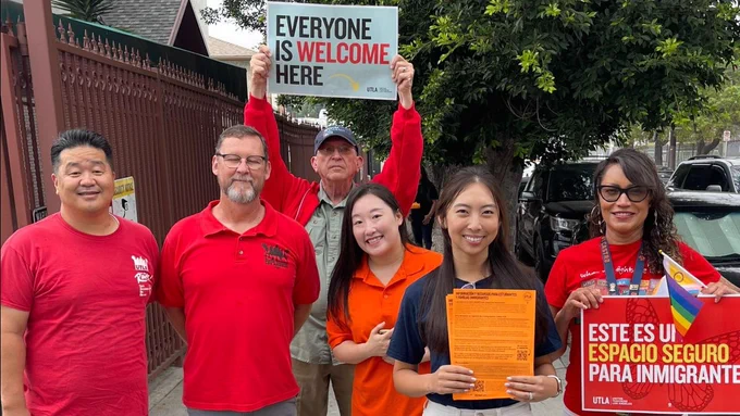 Group of members wearing red leaflet info for immigrant families.