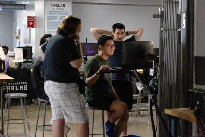 [ID: Pictured is a photo of three students working on a computer in the FabLab on the first floor of the UTA Central Library.]