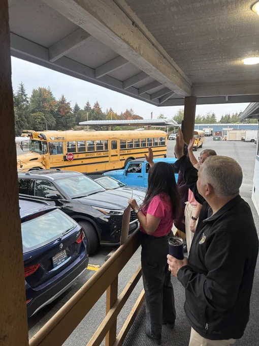 The UPSD Board of Directors waving to school buses on the first day of school.