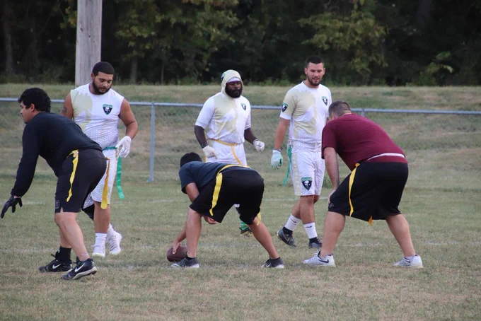 teams form two lines, facing eachother as on eplayers gets ready to begin a play.