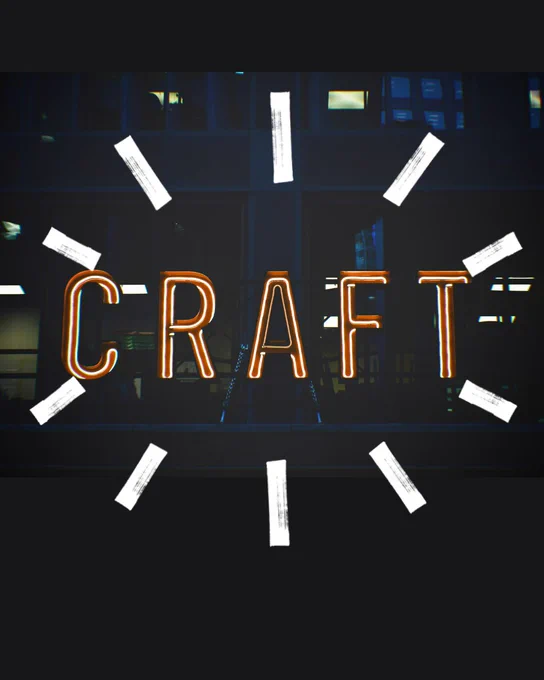 Neon sign spelling "CRAFT" displayed on a window with a dark building facade in the background.