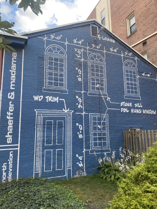 A building painted in the style of a blueprint, showing where windows and doors should be.