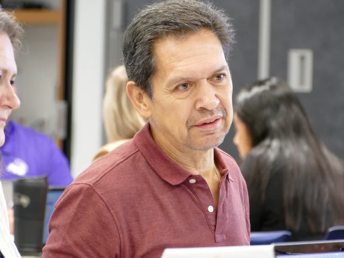 Person sitting in a meeting room and listening attentively.