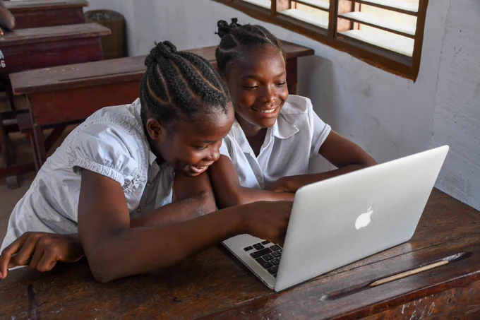 Image showing two girls helping each other to learn a concept using a laptop