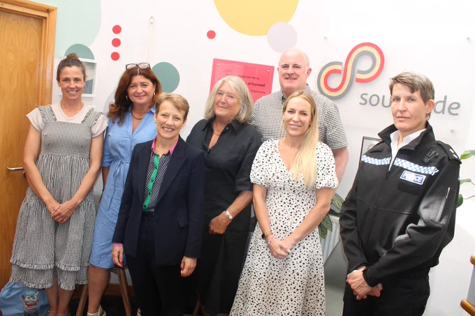 An image of Clare with 6 other people in front of a Southside sign in an office