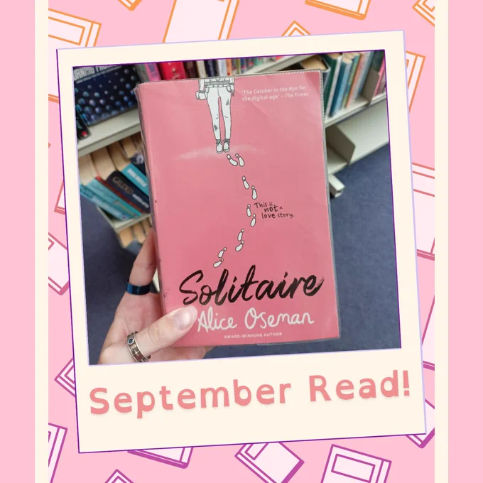 Photograph of a hand holding the book Solitaire by Alice Oseman in a polaroid frame graphic in front of a white graphic book tile against a pink background. Text on polaroid reads “September Read!”.
