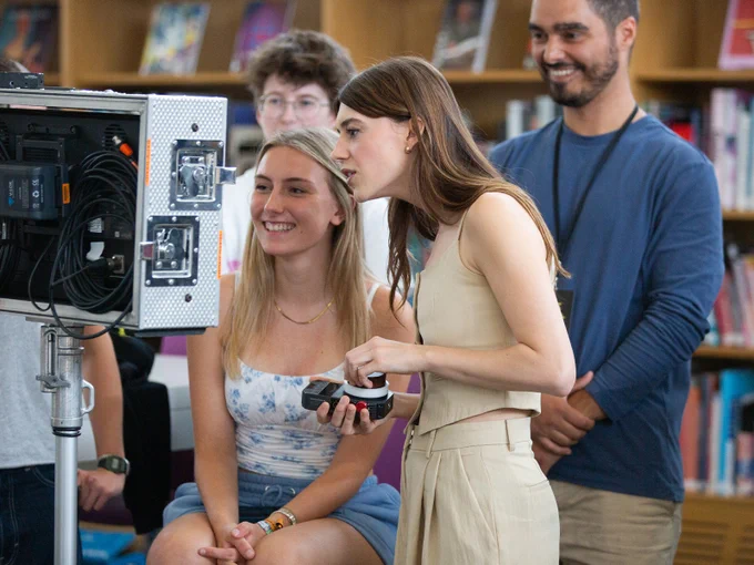Daisy Edgar-Jones looking at a camera with a group of other people 