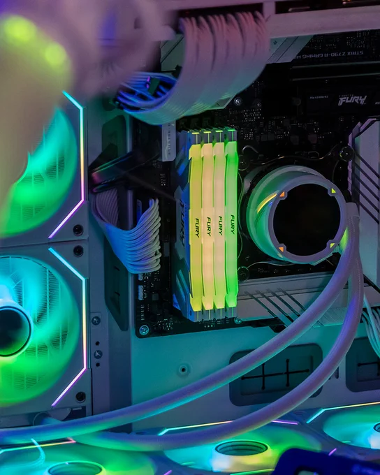Interior view of a computer showing a motherboard, Kingston FURY Renegade DDR5 RAM modules, and cooling systems with multicolored LED lights.