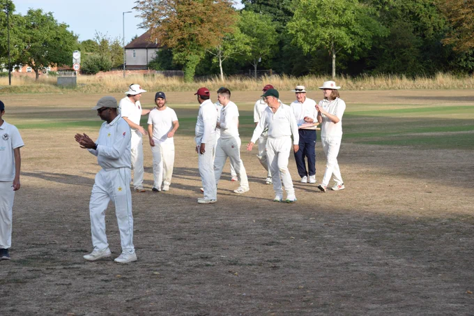 Bushmen team smile, shake hands and applaud as they leave the sun-baked field