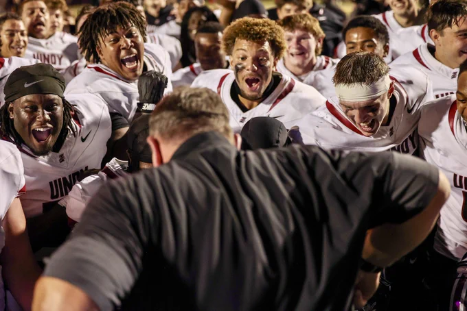 Members of the team scream and watch Coach Keevers dance after the win.