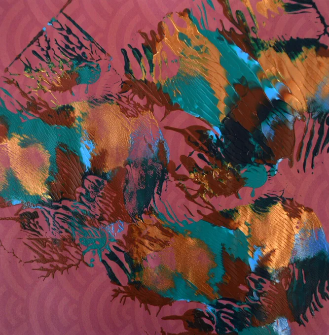 Homemade dendrite print made with splotches of different colored paint against origami paper.