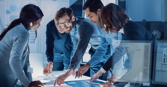 Image shows people collaborating and interacting in a workplace environment. 