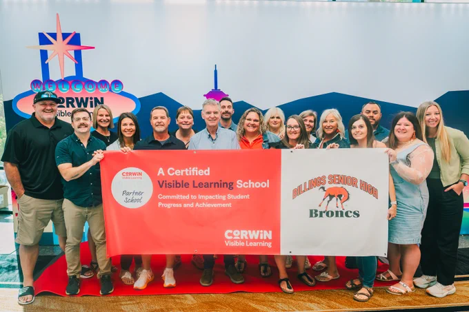 Group of educators holding a banner celebrating Billings Senior High as a certified Visible Learning School by Corwin.