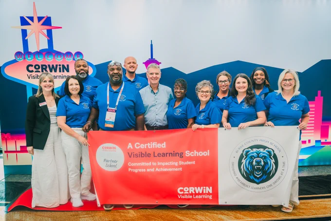 Group of educators holding a banner celebrating Burke County High School as a certified Visible Learning partner school by Corwin.