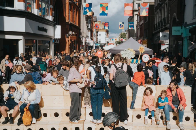 Several people of all ages sitting, standing and walking down George Street during last year's Centre Stage Festival