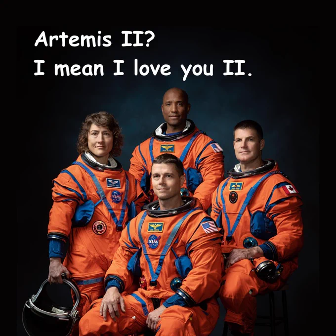 Four Artemis II astronauts in orange flight suits with the text: “Artemis II? I mean I love you II.” 
