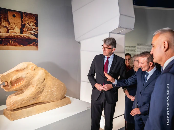 Wolfram Weimer bei Ausstellungsrundgang vor einer Tierstatue. 