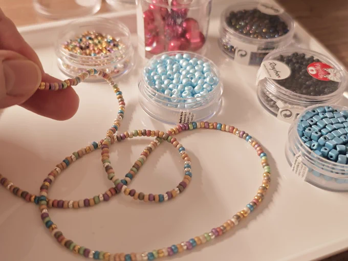 A necklace or bracelet. Colorful, small beads strung on string or thread.