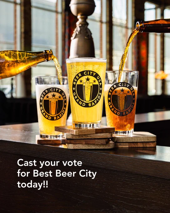 Three glasses filled with beer are being poured from bottles, each glass displaying the "Beer City USA Grand Rapids" logo. The glasses are on wooden coasters, and the background features a warm, rustic setting. Text in the image reads, "Cast your vote for Best Beer City today!!"