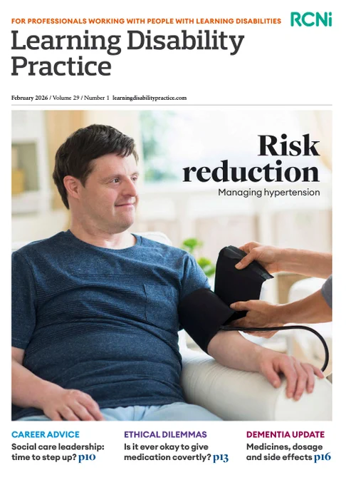 Man with a learning disability sits in an arm chair ready to have his blood pressure taken while nurse attaches the cuff to his arm.