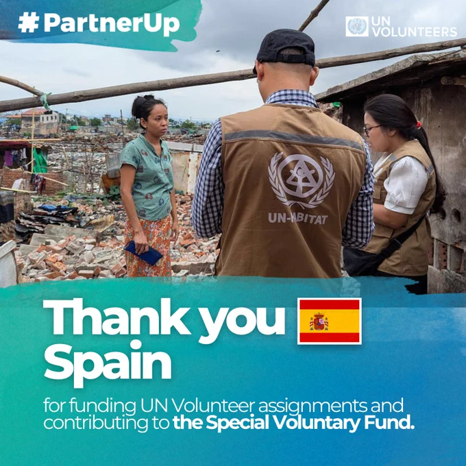 UN-Habitat volunteers engage with a local woman in a rubble-strewn area, highlighting Spain's support for UN Volunteer efforts.