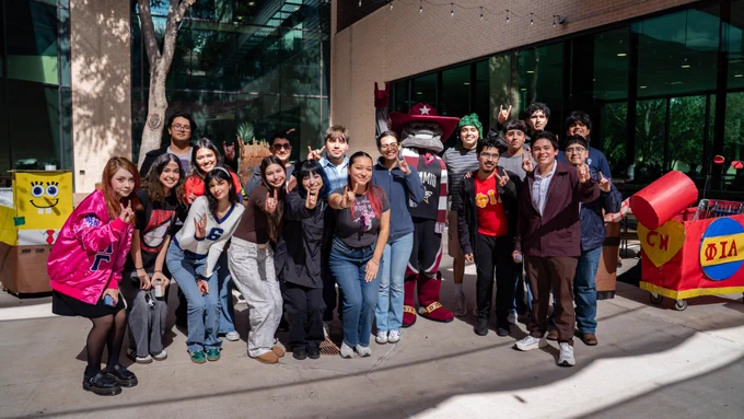 A group of TAMIU students smiling with Dusty the Dustdevil.