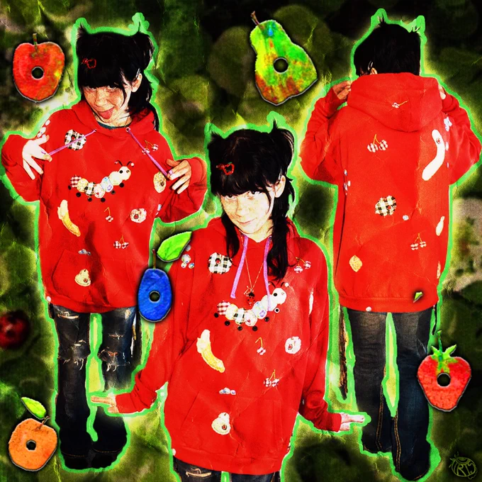 A promotional image for the ''SOOOOO HUNGRY'' hoodie, with 2 irises facing the camera and one other with back toward the camera to showcase the back. The hoodie itself is inspired by the Very Hungry Caterpillar story book, featuring patterned foods with holes in throughout with a textured caterpillar in the center.