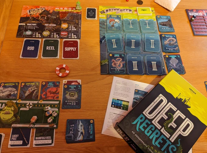 A board game, with sea-themed cards and counters, is laid out on a table.